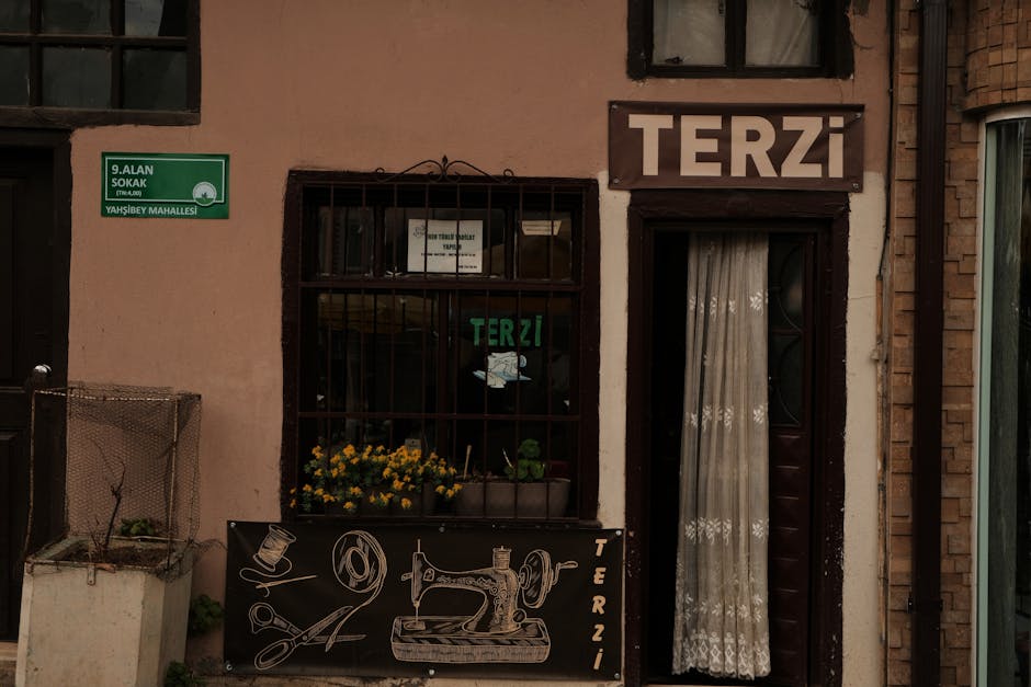 Charming facade of a tailor shop with vintage sewing decor and signage in an urban setting.